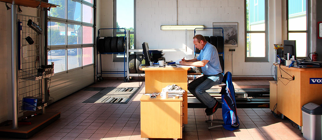 Ein Werkstattmitarbeiter an einem Arbeitsplatz mit Computer innerhalb der Werkstatt